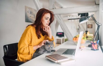 Woman working remotely with cat